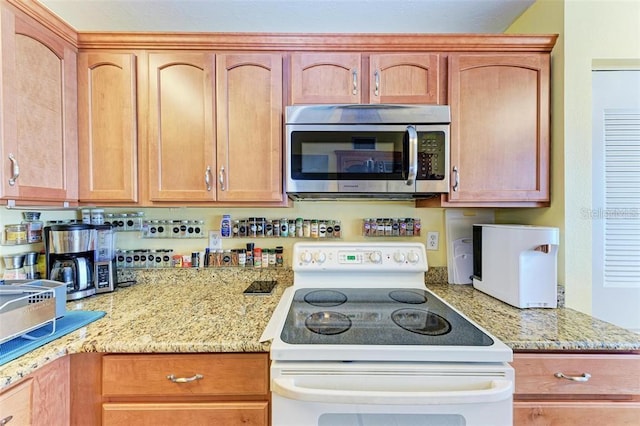 kitchen with electric stove and light stone countertops