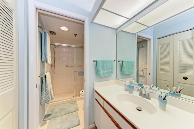 bathroom with tile patterned floors, toilet, vanity, and walk in shower