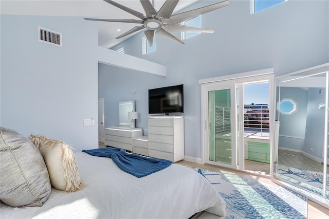 bedroom with hardwood / wood-style flooring, access to outside, high vaulted ceiling, and ceiling fan