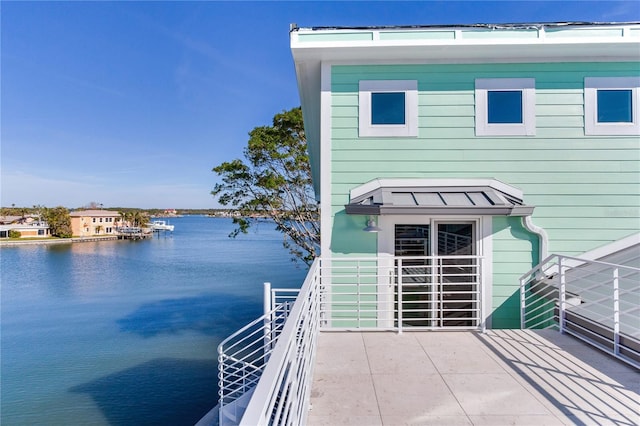 exterior space featuring a balcony and a water view