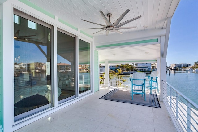 balcony with a water view and ceiling fan