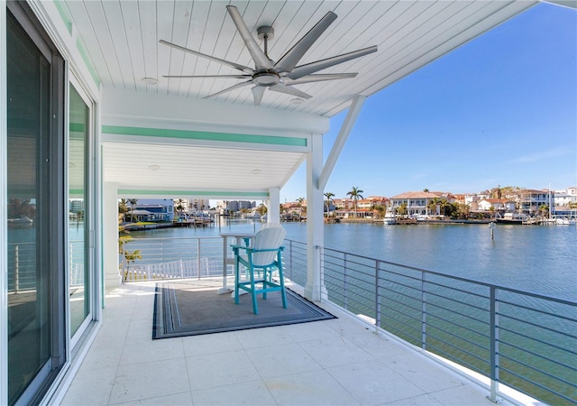 view of patio / terrace featuring ceiling fan, a water view, and a balcony