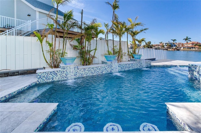 view of swimming pool with pool water feature and a water view