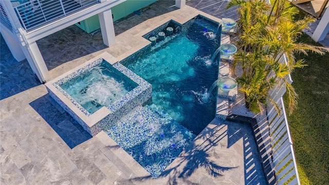 view of pool with an in ground hot tub and pool water feature