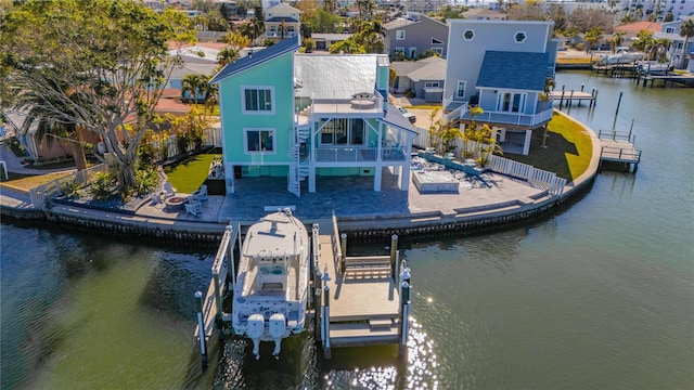 dock area featuring a water view, a balcony, and a patio