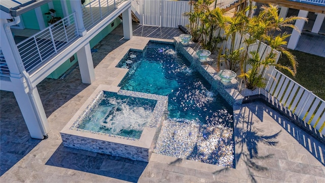 view of swimming pool featuring a patio, pool water feature, and an in ground hot tub