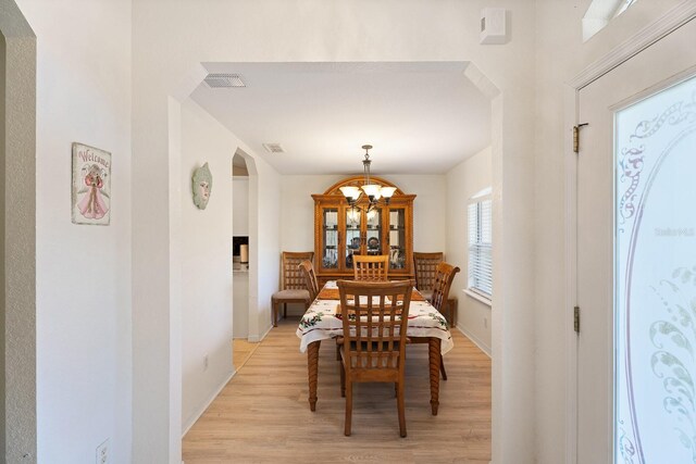 dining area with a chandelier and light hardwood / wood-style flooring