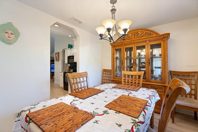 dining space featuring light hardwood / wood-style flooring and a chandelier