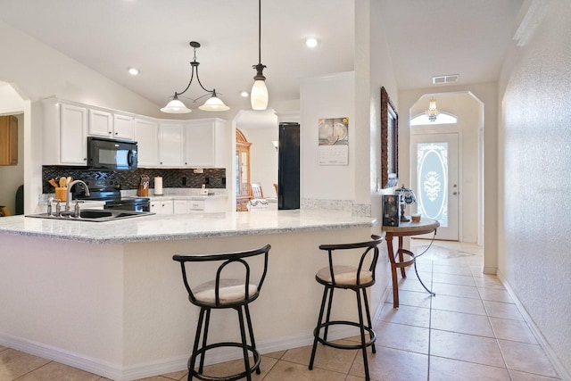 kitchen featuring stainless steel range with electric stovetop, pendant lighting, lofted ceiling, white cabinets, and kitchen peninsula