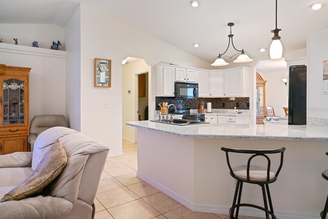 kitchen featuring white cabinets, kitchen peninsula, vaulted ceiling, and stainless steel range with electric stovetop