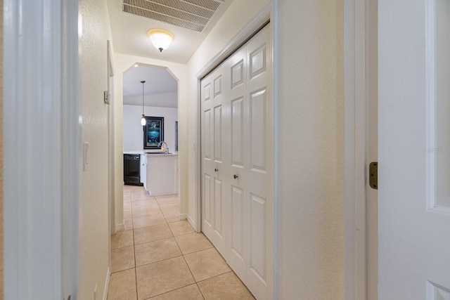 corridor with light tile patterned floors and sink