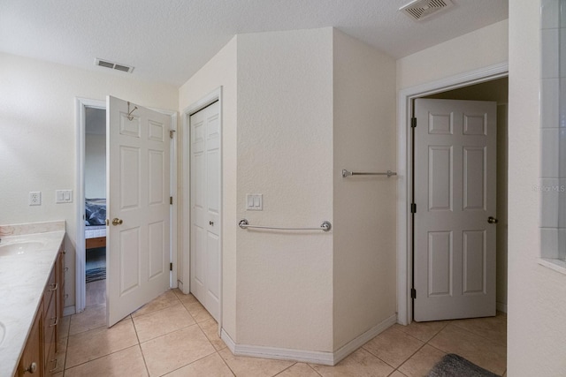 bathroom with vanity, a textured ceiling, and tile patterned floors