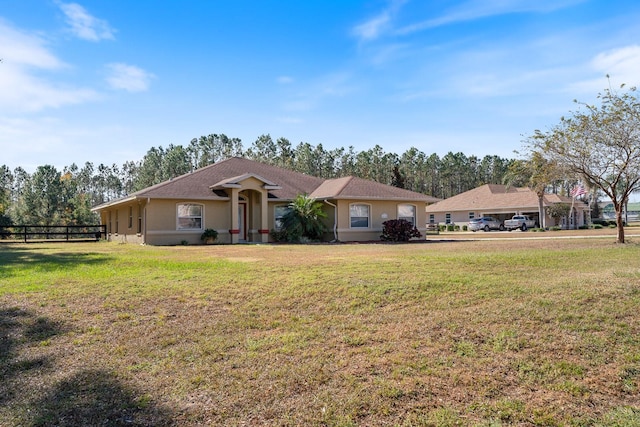 single story home with a front yard, stucco siding, and fence