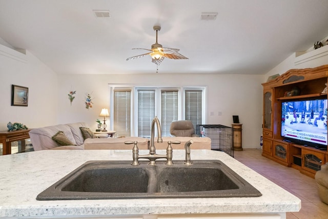 kitchen featuring open floor plan, a sink, light tile patterned flooring, and visible vents