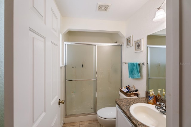 full bathroom featuring toilet, vanity, a stall shower, and visible vents