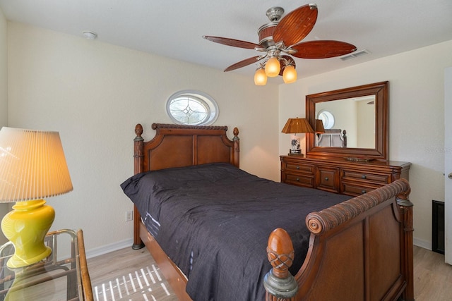bedroom featuring a ceiling fan, visible vents, baseboards, and light wood-type flooring
