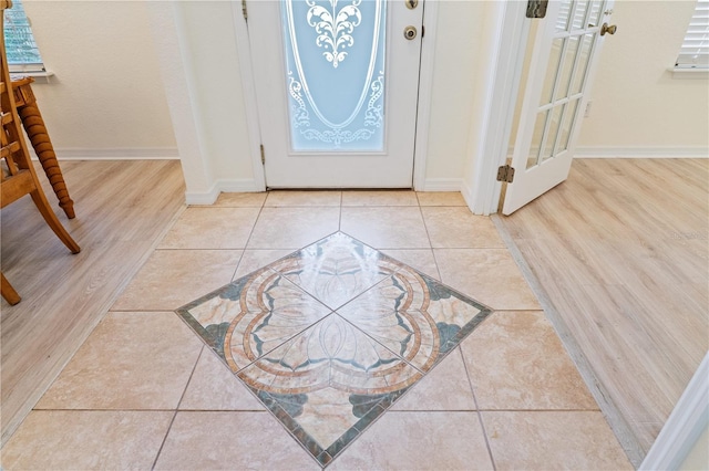 tiled foyer entrance featuring baseboards