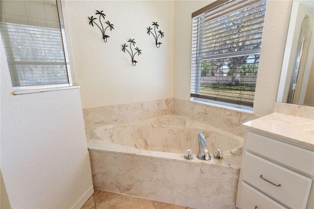 full bathroom featuring a bath, tile patterned floors, and vanity