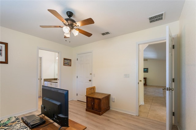 interior space featuring baseboards, visible vents, light wood-type flooring, and a ceiling fan