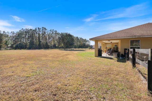 view of yard with a ceiling fan, fence, and a patio