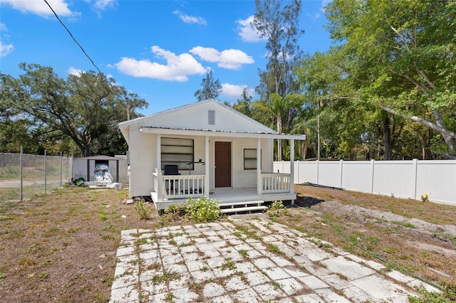 view of front of house featuring covered porch and an outbuilding