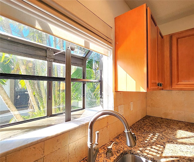 details with light stone counters, sink, and tasteful backsplash