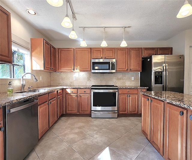 kitchen featuring decorative light fixtures, sink, and appliances with stainless steel finishes