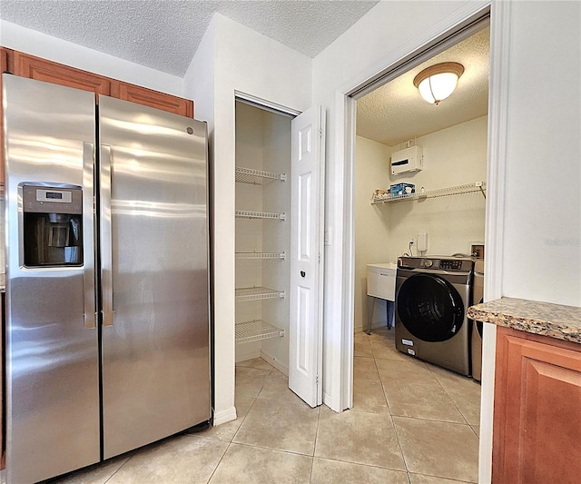 interior space featuring a textured ceiling, washer / clothes dryer, and light tile patterned flooring