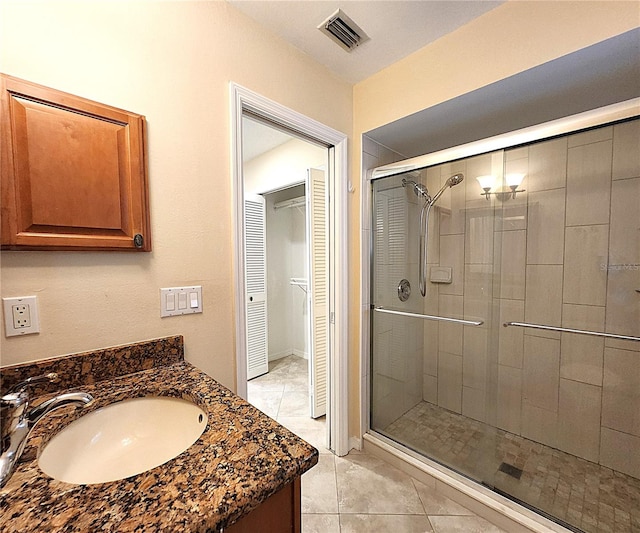 bathroom featuring vanity, tile patterned floors, and a shower with door