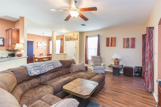 living room featuring ceiling fan and dark hardwood / wood-style flooring