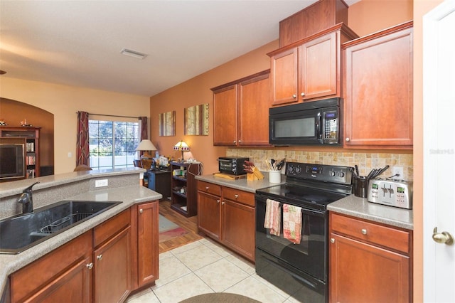 kitchen featuring backsplash, sink, light tile patterned floors, and black appliances