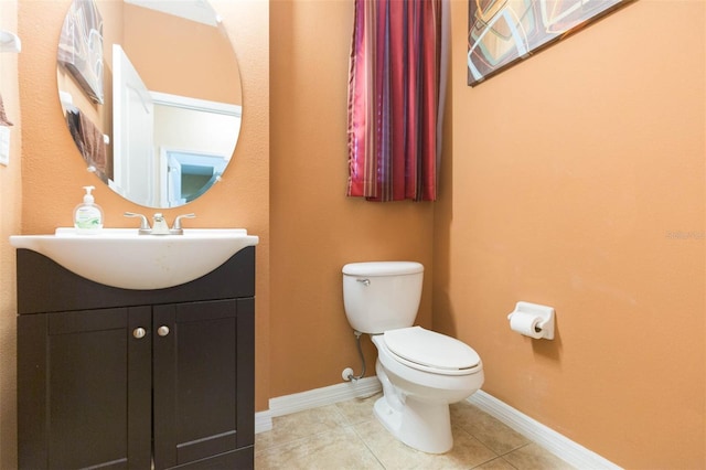 bathroom with tile patterned flooring, vanity, and toilet