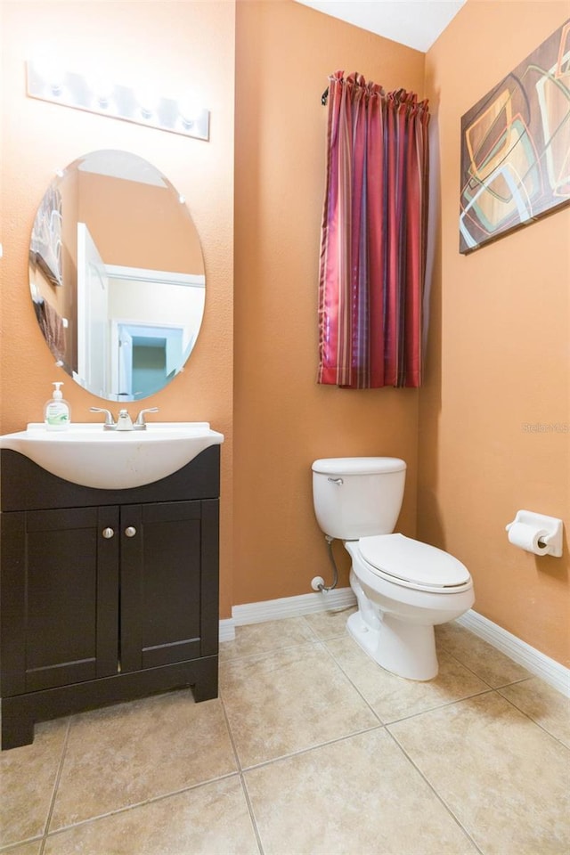 bathroom with tile patterned floors, vanity, and toilet