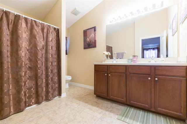 bathroom featuring tile patterned floors, vanity, vaulted ceiling, and toilet