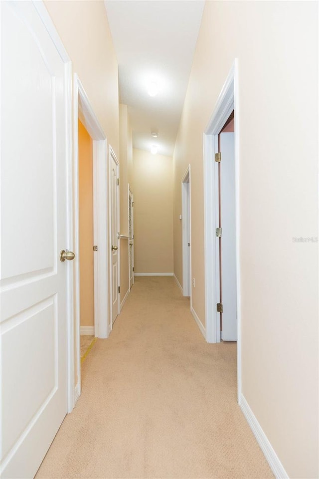 hall with light colored carpet