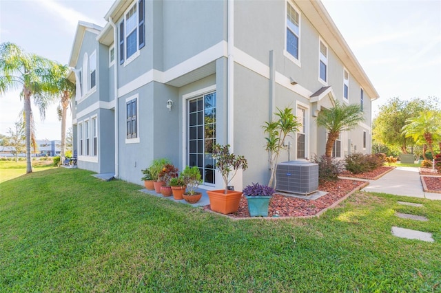 view of home's exterior with a lawn and central AC