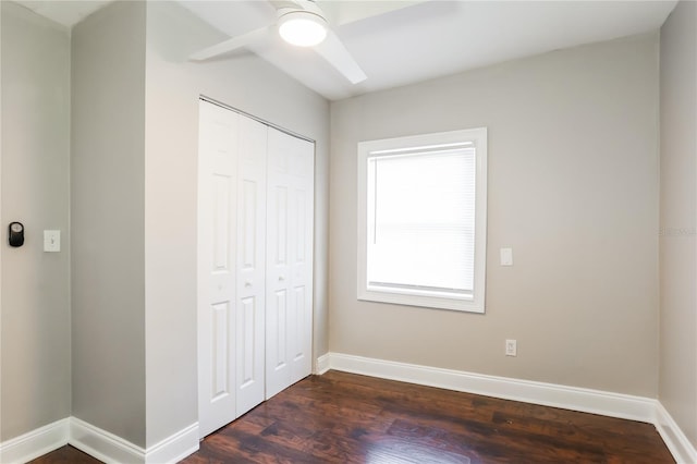 unfurnished bedroom with dark hardwood / wood-style flooring, a closet, and ceiling fan