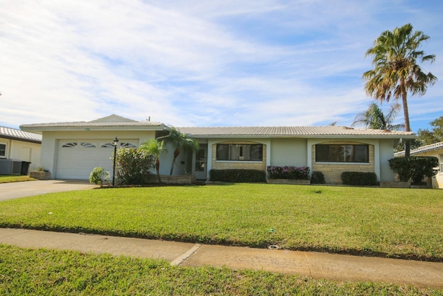 ranch-style home featuring central AC, a garage, and a front yard