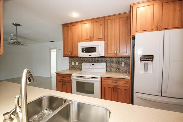 kitchen featuring tasteful backsplash, ceiling fan, sink, and white appliances