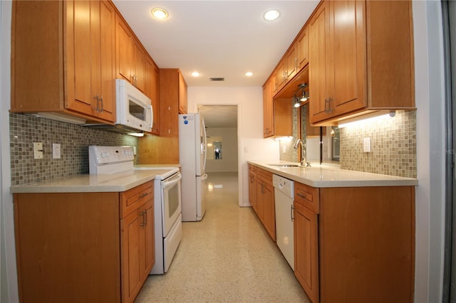 kitchen featuring tasteful backsplash, white appliances, and sink