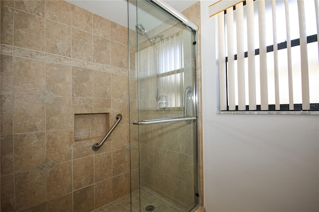 bathroom featuring a shower with shower door