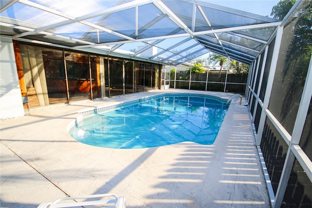 view of pool with a patio area and glass enclosure