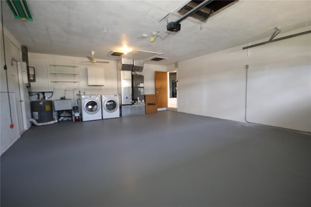 garage with sink, a garage door opener, electric water heater, heating unit, and washer and dryer