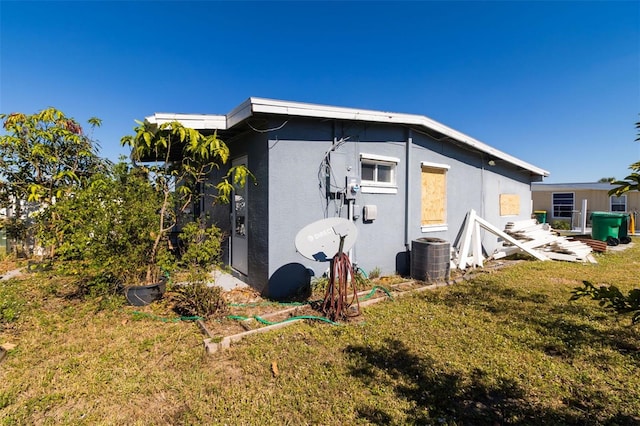 view of side of home with a yard and central air condition unit