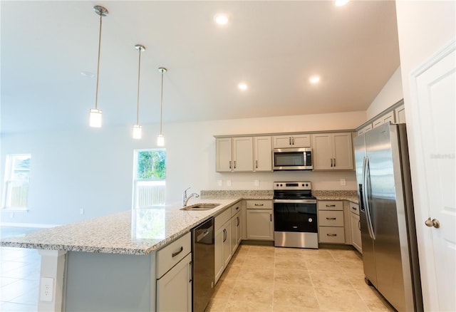 kitchen featuring light stone counters, kitchen peninsula, pendant lighting, vaulted ceiling, and appliances with stainless steel finishes