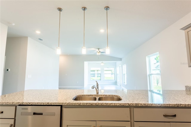 kitchen with stainless steel dishwasher, ceiling fan, light stone counters, and sink