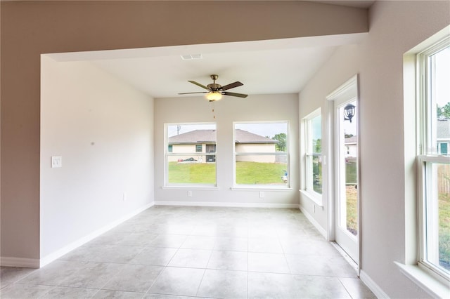 unfurnished sunroom featuring ceiling fan