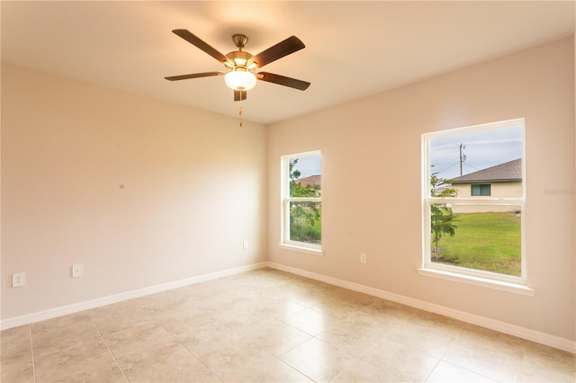 tiled spare room featuring ceiling fan