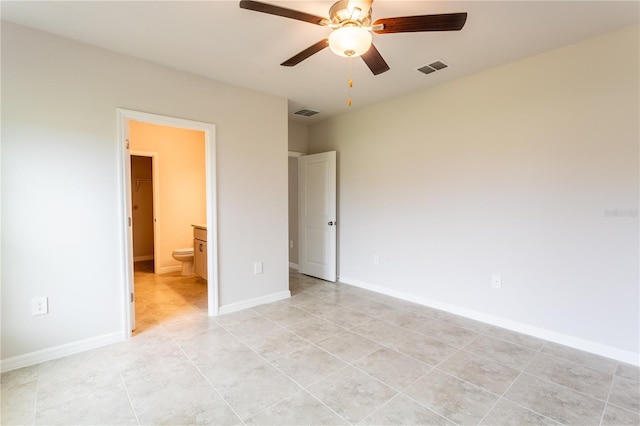 unfurnished bedroom with light tile patterned floors, ensuite bath, and ceiling fan