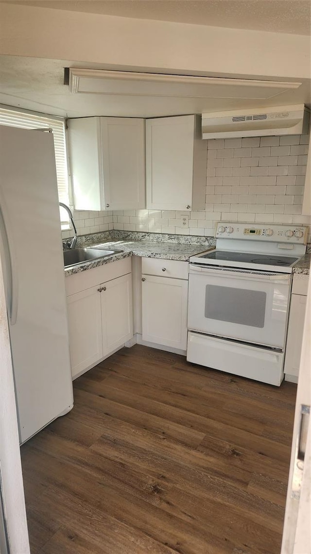 kitchen featuring white appliances, decorative backsplash, dark hardwood / wood-style flooring, white cabinetry, and extractor fan